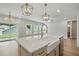 This open kitchen is filled with stainless steel appliances, a farmhouse sink, and a large island at 4477 Bethany Manor Dr, Snellville, GA 30039