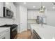 This spacious kitchen includes stainless steel appliances, quartz counters, and a farmhouse sink at 4477 Bethany Manor Dr, Snellville, GA 30039