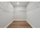 Walk-in closet with wood-look flooring and shelving ready for organization at 4477 Bethany Manor Dr, Snellville, GA 30039
