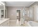 Large bathroom with double vanity, glass shower, soaking tub, and white tile at 970 N Ormewood Park Se Dr, Atlanta, GA 30316