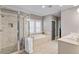 Well-lit bathroom featuring a soaking tub, glass shower, double vanity, and modern fixtures at 970 N Ormewood Park Se Dr, Atlanta, GA 30316