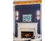Fireplace with blue accent wall, custom lighting, and a classic white mantle at 970 N Ormewood Park Se Dr, Atlanta, GA 30316