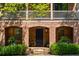 Close-up of the brick front entrance with an arched doorway, black door, and manicured landscaping at 970 N Ormewood Park Se Dr, Atlanta, GA 30316