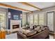 Cozy living room with a fireplace, exposed wood beams, plantation shutters, and a comfortable leather sofa at 970 N Ormewood Park Se Dr, Atlanta, GA 30316