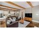 Inviting living room with exposed wood beams, hardwood floors, open layout to the kitchen, and modern decor at 970 N Ormewood Park Se Dr, Atlanta, GA 30316