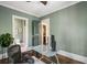 Bright home office featuring sleek glass desk, hardwood floors, and a convenient view of the adjacent bathroom at 970 N Ormewood Park Se Dr, Atlanta, GA 30316