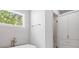 Bathroom featuring a large window, white soaking tub, and modern white cabinets at 126 Owens Mill Pl, Canton, GA 30115