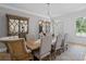 Elegant dining room with stylish light fixture, paneled walls, hardwood floors, and comfortable seating for eight guests at 126 Owens Mill Pl, Canton, GA 30115
