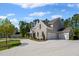 Stone and siding home showcasing a spacious three-car garage and manicured lawn at 126 Owens Mill Pl, Canton, GA 30115