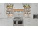 Modern kitchen with white cabinetry, floating shelves, stainless steel range, and sleek design at 126 Owens Mill Pl, Canton, GA 30115