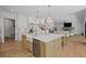 Open concept kitchen features a large island with a view to the living room with a fireplace at 126 Owens Mill Pl, Canton, GA 30115