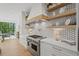 Well-lit kitchen with open shelving, a professional range, and views of the outdoor dining area at 126 Owens Mill Pl, Canton, GA 30115