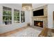 Bright living room featuring a stone fireplace, light hardwood floors, and three large windows that fill the space with natural light at 126 Owens Mill Pl, Canton, GA 30115