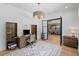 Home office boasts hardwood floors, stylish light fixture, and custom built-in desk and shelving adjacent to the formal dining room at 126 Owens Mill Pl, Canton, GA 30115