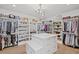 A large walk-in closet with shelving, racks, a central island, and a hanging chandelier at 126 Owens Mill Pl, Canton, GA 30115