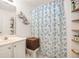 Bathroom with white vanity, blue patterned shower curtain, and open shelving at 2770 Nautical Way, Villa Rica, GA 30180