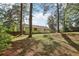 Green backyard with a classic home, bordered by mature trees and providing shade at 4954 Browns Mill Rd, Lithonia, GA 30038