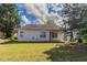 Back exterior view of home with white siding and a spacious green yard with shade trees at 7161 Boulder Pass, Union City, GA 30291