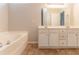 Well-lit primary bathroom featuring double vanity, separate tub and neutral paint at 7161 Boulder Pass, Union City, GA 30291
