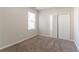 This bedroom features neutral walls, soft carpet, and a double-doored closet with a window nearby at 7161 Boulder Pass, Union City, GA 30291