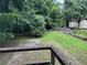 Backyard featuring grassy area, mature trees and vegetation, storage sheds and partial fencing at 1142 Pluma Se Dr, Atlanta, GA 30316