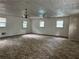 Spacious living room with neutral-toned carpet, multiple windows, and a vintage chandelier at 1142 Pluma Se Dr, Atlanta, GA 30316