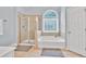 A bright bathroom featuring a separate shower and tub with a large window at 1255 Hidden Creek Pt, Cumming, GA 30040