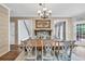 Dining room featuring farmhouse style table, overhead chandelier, and view to the outdoor deck at 1255 Hidden Creek Pt, Cumming, GA 30040