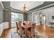 Formal dining room with wainscoting, tray ceiling, chandelier, and natural light at 1255 Hidden Creek Pt, Cumming, GA 30040