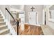 Inviting foyer with wood floors, staircase, and an open view to dining room at 1255 Hidden Creek Pt, Cumming, GA 30040