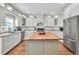 Bright eat-in kitchen featuring stainless appliances, center island with butcher block, and white cabinetry at 1255 Hidden Creek Pt, Cumming, GA 30040