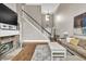 Open-concept living area with fireplace, hardwood floors, and natural light from tall windows at 1255 Hidden Creek Pt, Cumming, GA 30040