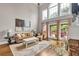 Comfortable living room with soaring ceilings, large windows, fireplace and hardwood floors at 1255 Hidden Creek Pt, Cumming, GA 30040