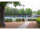 Community tennis court with well-maintained surface and lighting for evening play at 1255 Hidden Creek Pt, Cumming, GA 30040