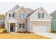 Charming two-story home featuring a brick and gray facade, a two-car garage, and a well-manicured lawn at 1730 Fulmont Cir, Mableton, GA 30126