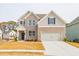 Charming two-story home featuring a brick and gray facade, a two-car garage, and a well-manicured lawn at 1730 Fulmont Cir, Mableton, GA 30126