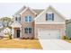 Charming two-story home featuring a brick and gray facade, a two-car garage, and a well-manicured lawn at 1730 Fulmont Cir, Mableton, GA 30126