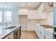 A well-lit kitchen features white cabinets, stainless steel appliances, a kitchen island, and elegant countertops at 1730 Fulmont Cir, Mableton, GA 30126