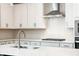 This kitchen boasts white cabinets, stainless steel appliances and hardware, and a geometric backsplash at 1730 Fulmont Cir, Mableton, GA 30126