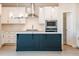 A modern kitchen showcases white cabinetry, a contrasting island, stainless steel appliances, and stylish pendant lighting at 1730 Fulmont Cir, Mableton, GA 30126