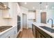 A modern kitchen is designed with white cabinetry, a spacious island, and stainless steel appliances at 1730 Fulmont Cir, Mableton, GA 30126