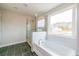 Bright bathroom featuring soaking tub and glass-enclosed shower next to a large window at 1730 Fulmont Cir, Mableton, GA 30126