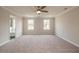 Expansive main bedroom has neutral carpet, ceiling fan, and view of bathroom and windows at 1730 Fulmont Cir, Mableton, GA 30126