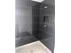 Modern walk-in shower with stylish dark tile, featuring a built-in niche and corner seat at 1730 Fulmont Cir, Mableton, GA 30126