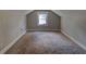 Spacious attic area with carpet, neutral walls, and natural light from a window at 246 Stafford Nw St, Atlanta, GA 30314