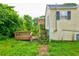 Home's rear exterior showing a wooden deck and steps to grade amid overgrown vegetation at 246 Stafford Nw St, Atlanta, GA 30314
