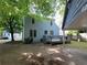Side of blue two-story home with deck, green trash bin, carport and paved driveway at 4 Kelso At Peyton Sw Dr, Atlanta, GA 30311