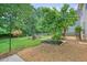 Beautifully landscaped backyard featuring lush lawn, stone-lined gardens, and a charming seating area at 510 Morning Mist Ct, Alpharetta, GA 30022
