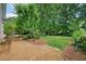 Serene backyard oasis with lush landscaping, mature trees, and seating area at 510 Morning Mist Ct, Alpharetta, GA 30022