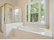 Bathtub next to a window with natural light with a glass shower to the side at 510 Morning Mist Ct, Alpharetta, GA 30022